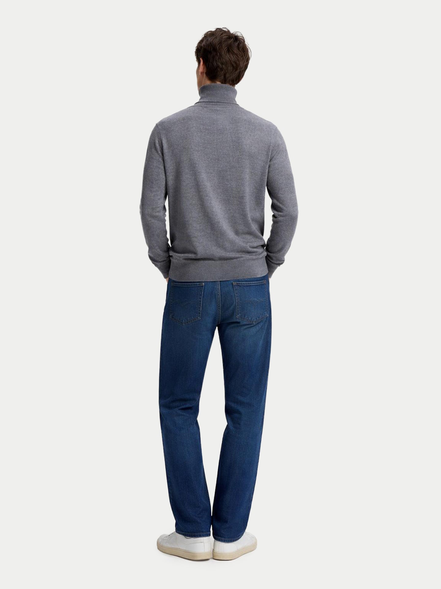 Vue de dos d'un homme portant un pull à col roulé gris et un jean bleu sur fond gris clair. #color_gris-foncé