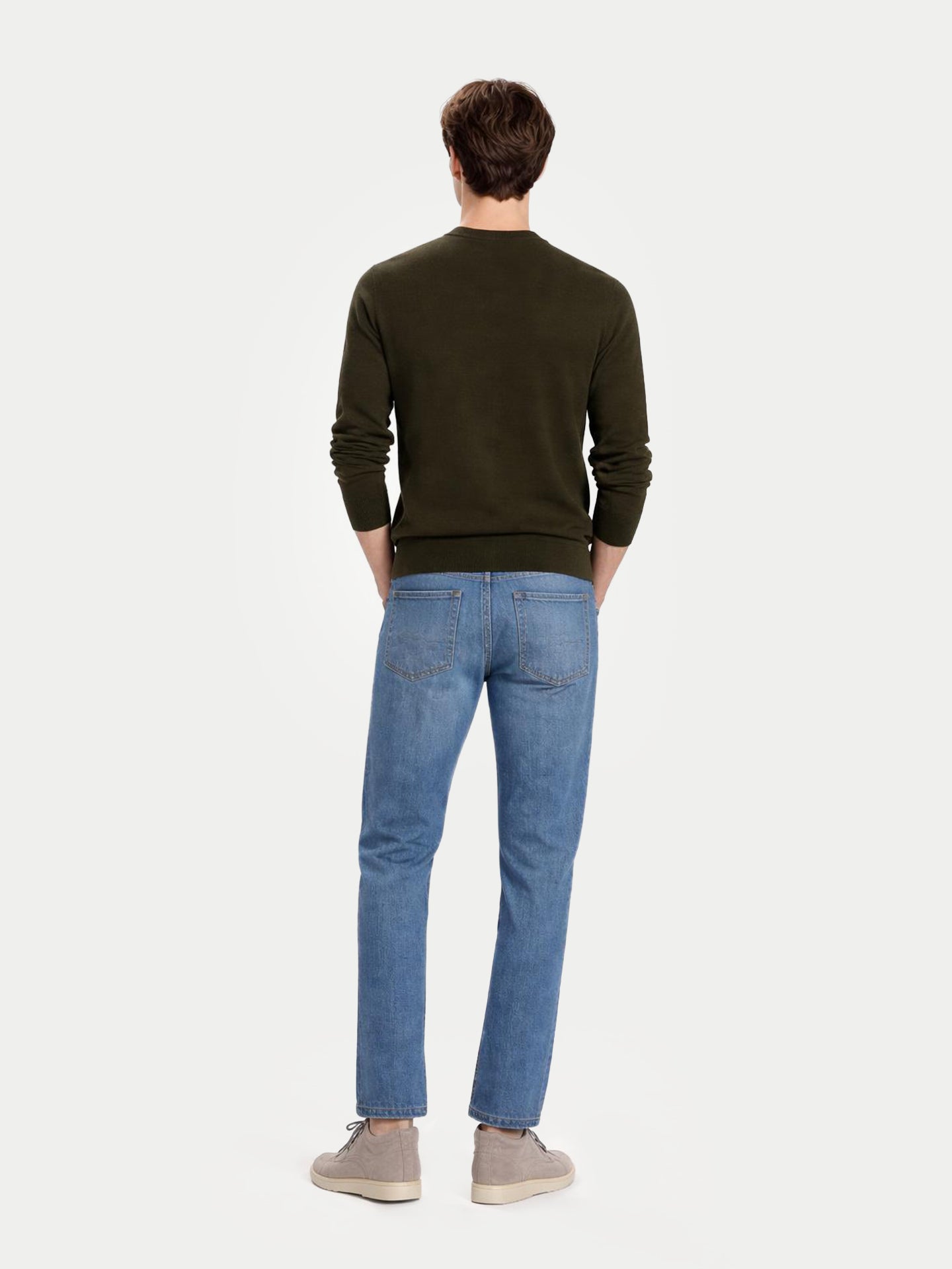 Vue de dos d'un homme portant un pull vert foncé à col rond et un jean bleu sur fond gris clair. #color_avocado