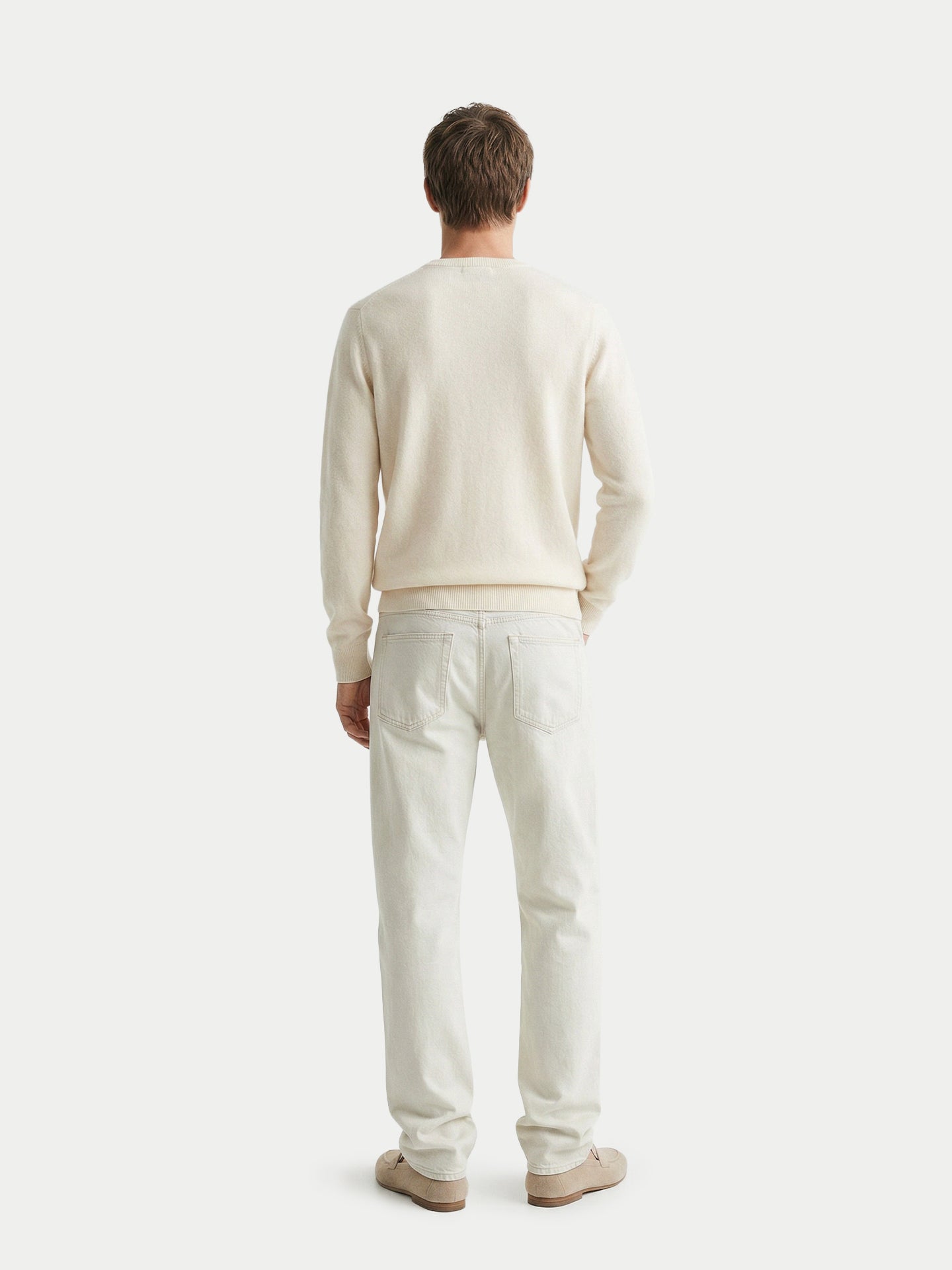 Vue de dos d'un homme portant un pull blanc et un pantalon blanc sur fond gris clair. #color_blanc-cassé