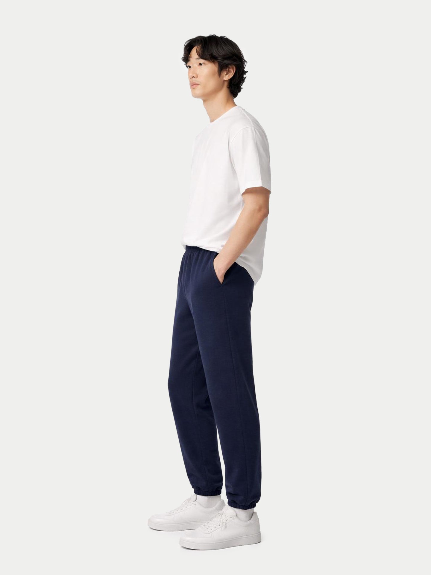 Vue de face d'un homme portant un t-shirt blanc et un pantalon de jogging bleu marine à poches.
#color_india-ink