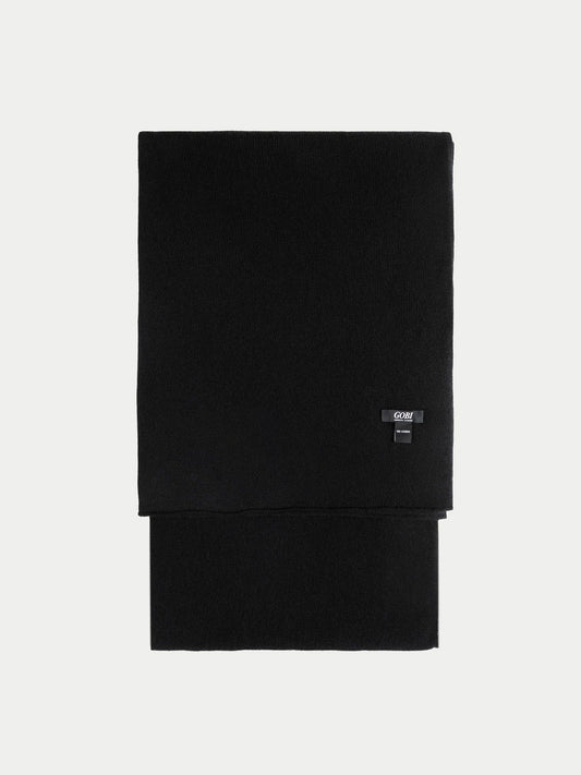 Vue de face d'une écharpe noire avec une petite étiquette de marque « GOBI » sur fond gris clair. #color_noir