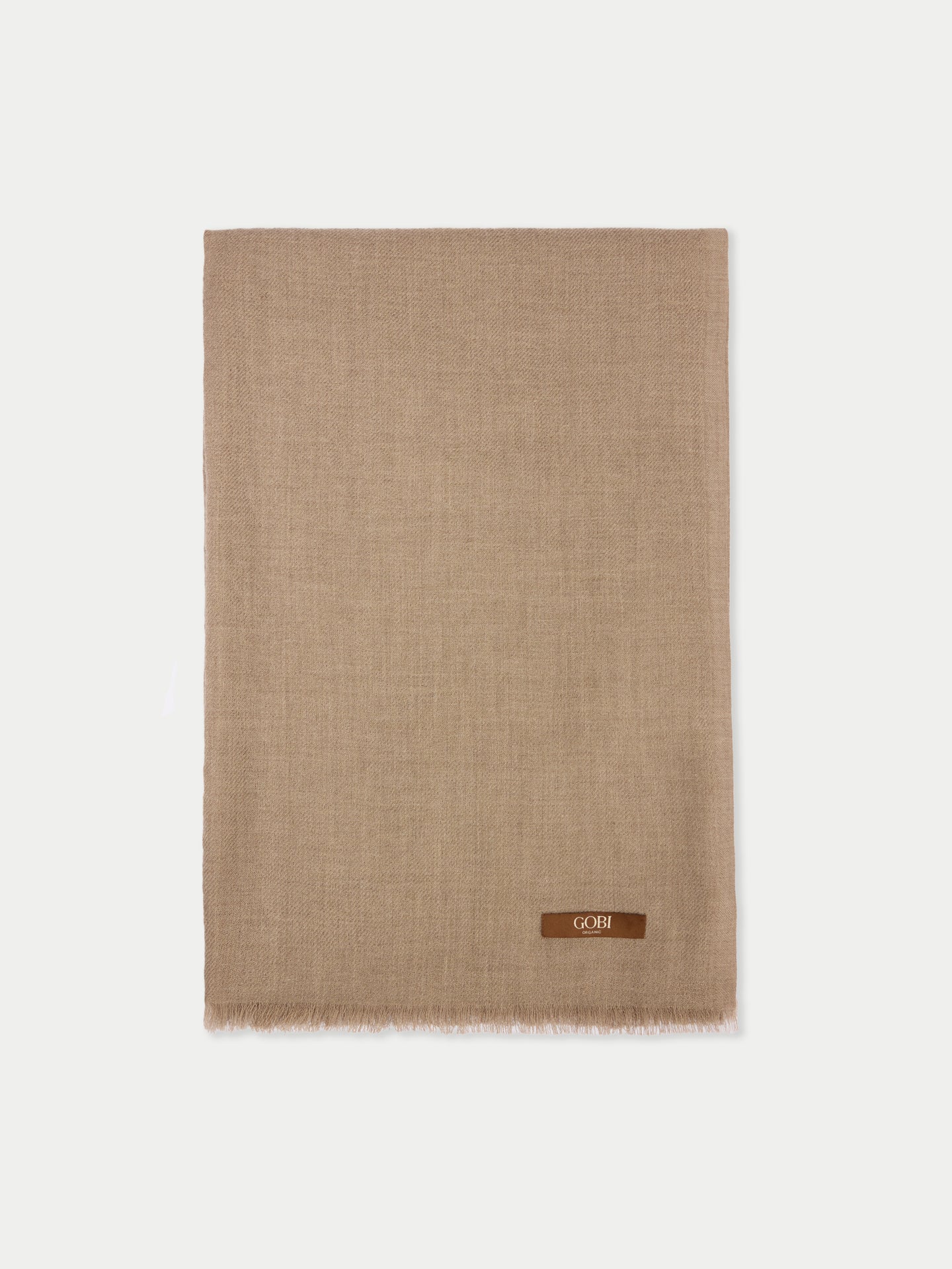 Une écharpe beige avec une petite étiquette de marque "GOBI" sur un fond gris clair. #color_beige