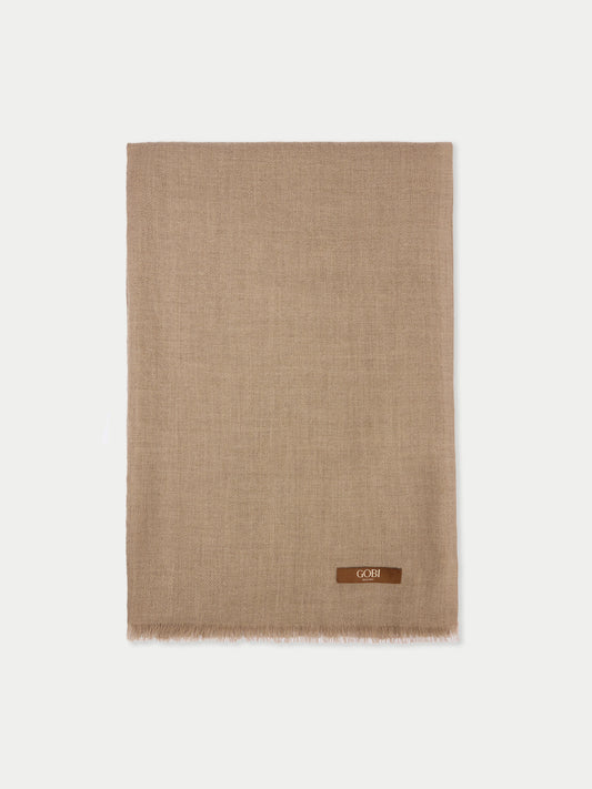Une écharpe beige avec une petite étiquette de marque "GOBI" sur un fond gris clair. #color_beige