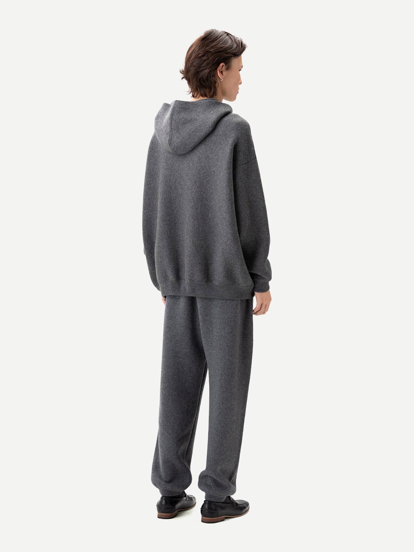 Vue de dos d'un homme portant un ensemble sweat à capuche et jogging gris assortis sur fond gris clair. #color_plum-kitten