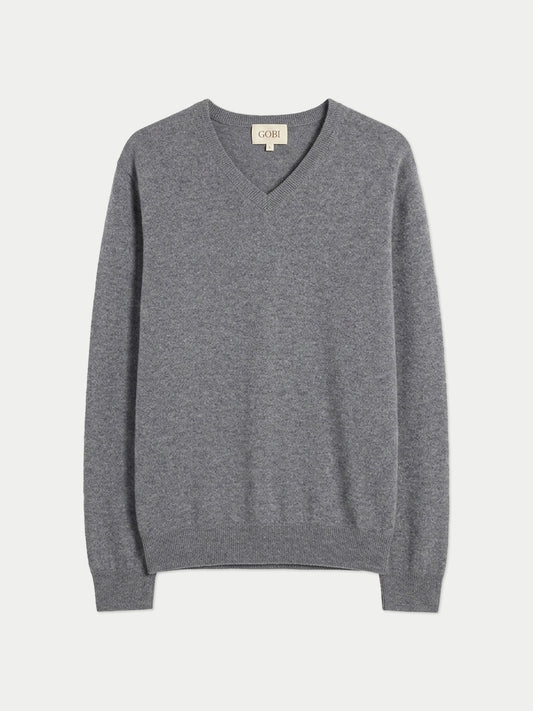 Vue de face d'un pull gris à col en V sur fond gris clair. #color_gris-foncé