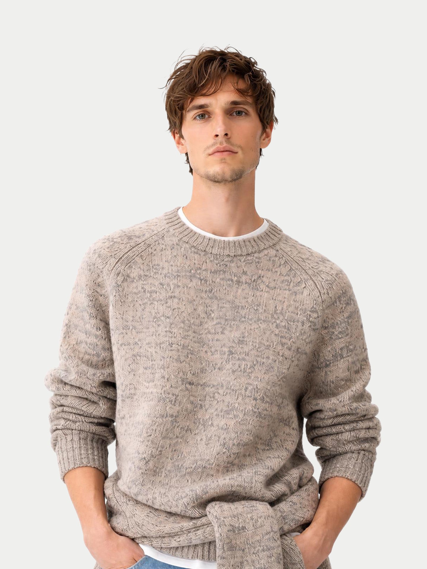 Gros plan de face d'un homme portant un pull ras du cou côtelé beige-taupe sur un t-shirt blanc, sur fond gris clair. #color_oxfor-tan