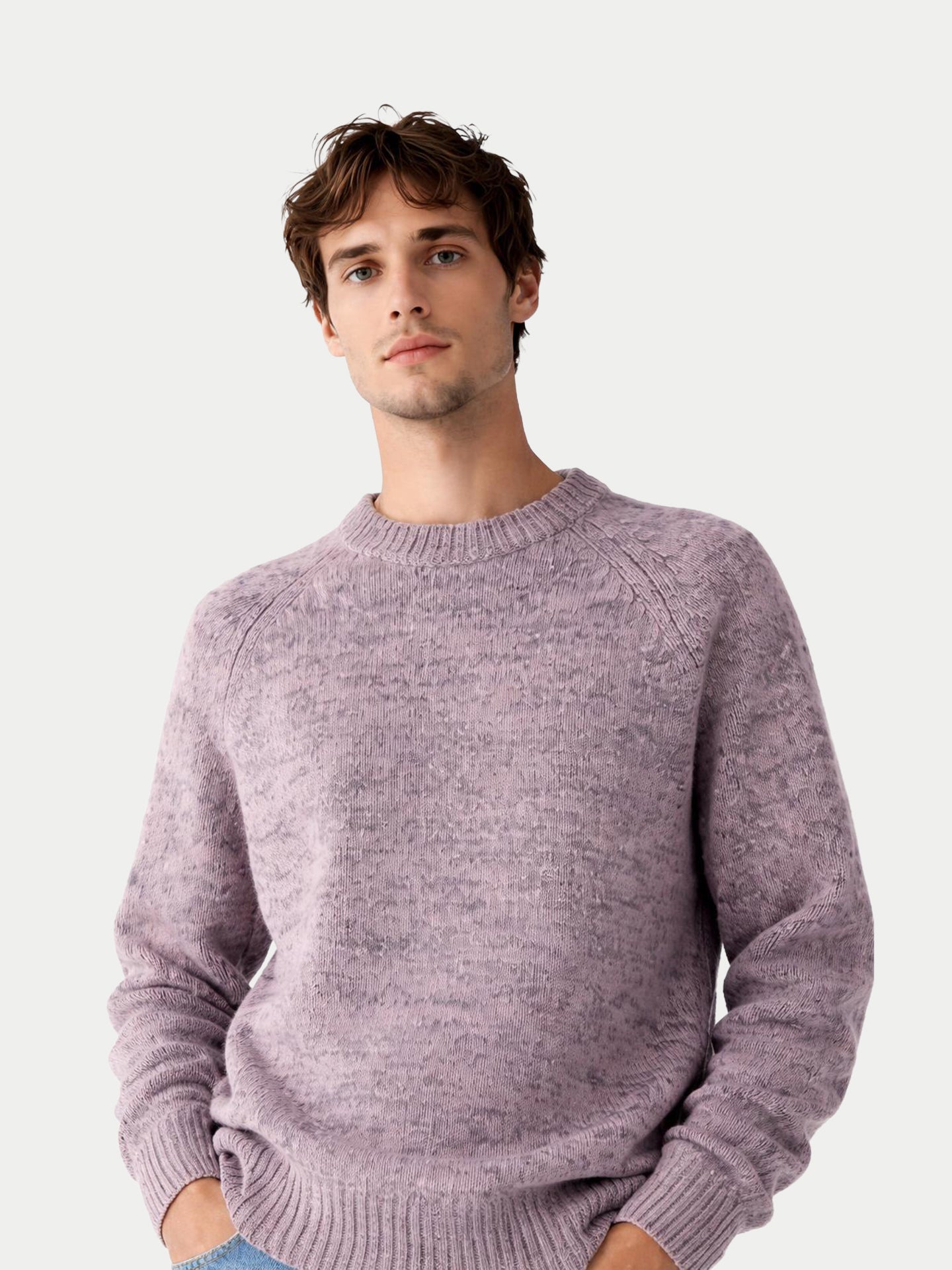 Gros plan de face d'un homme portant un pull à col rond rose-gris sur fond gris clair. #color_rose-ivoire