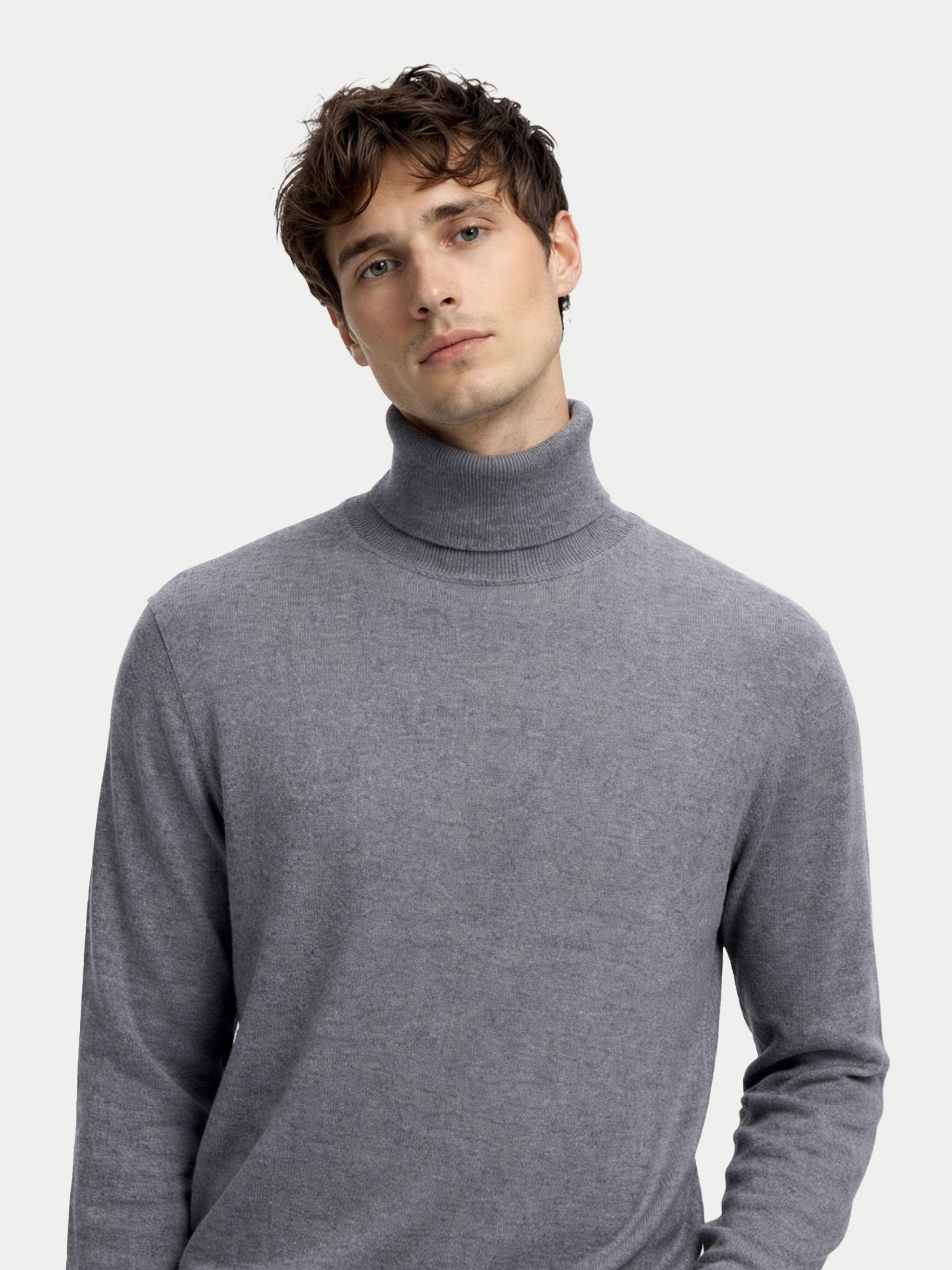 Gros plan de face d'un homme portant un pull à col roulé gris sur fond gris clair. #color_gris-foncé