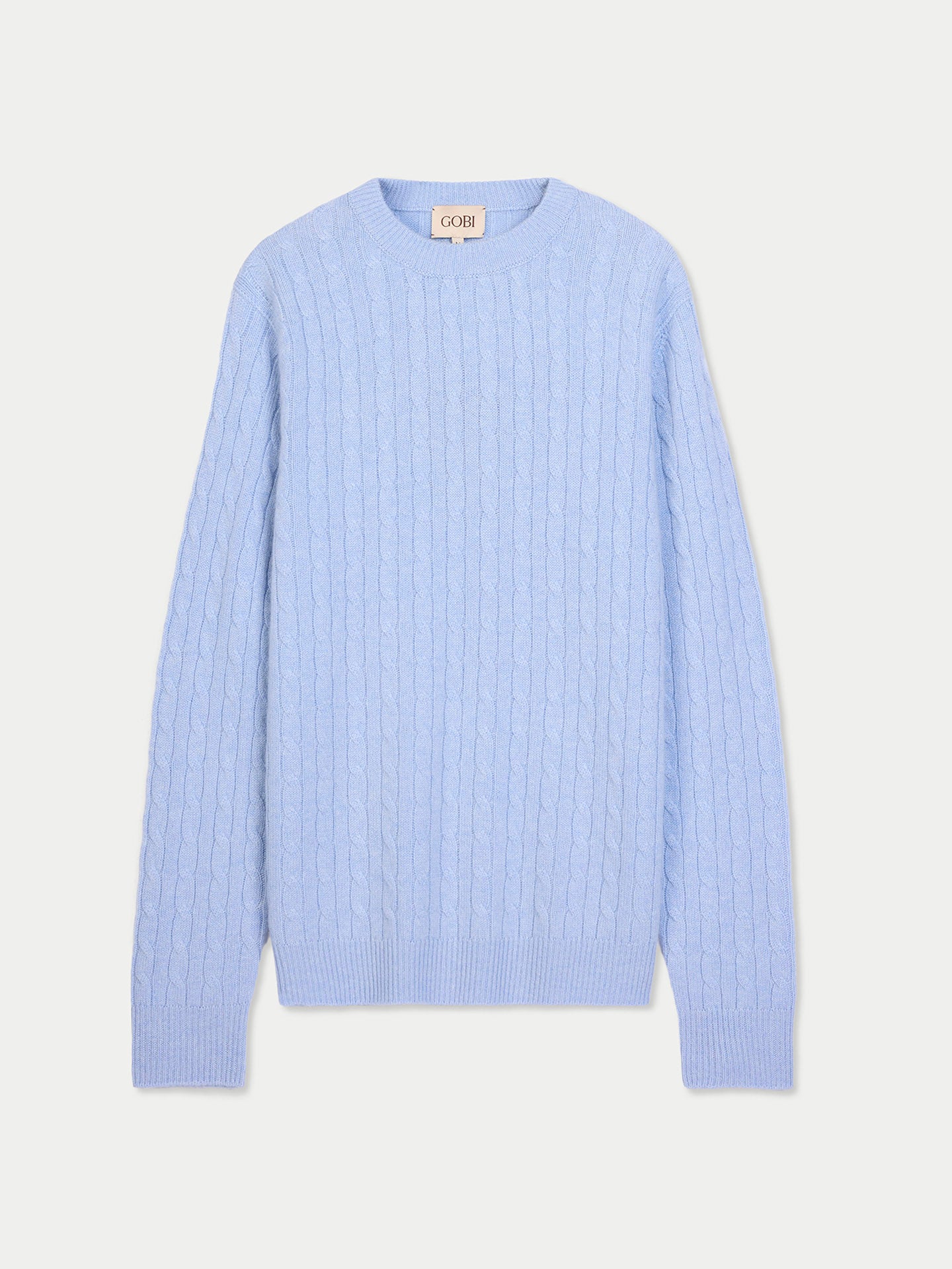 Vue de face d'un pull en maille torsadée bleu clair sur fond gris clair. #color_bleu-clair