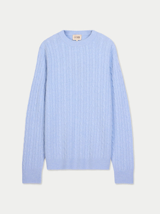 Vue de face d'un pull en maille torsadée bleu clair sur fond gris clair. #color_bleu-clair