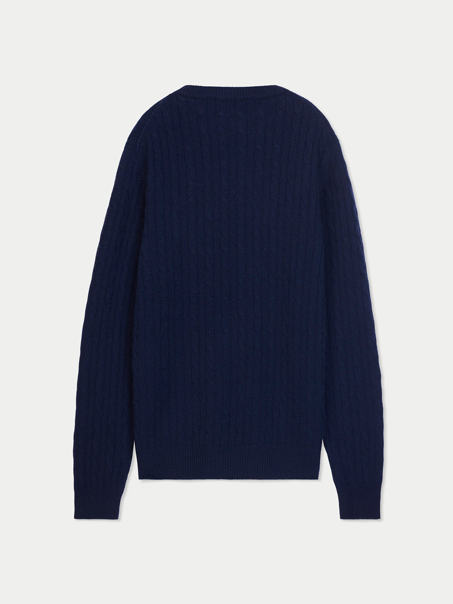 Vue de face d'un pull en maille torsadée bleu marine sur fond gris clair. #color_navy