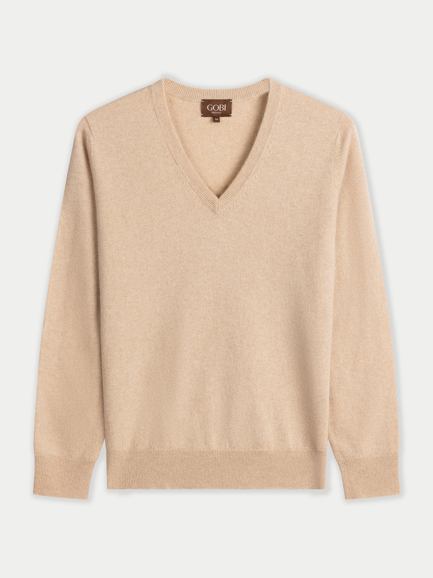 Vue de face d'un pull beige à col en V sur fond gris clair. #color_beige