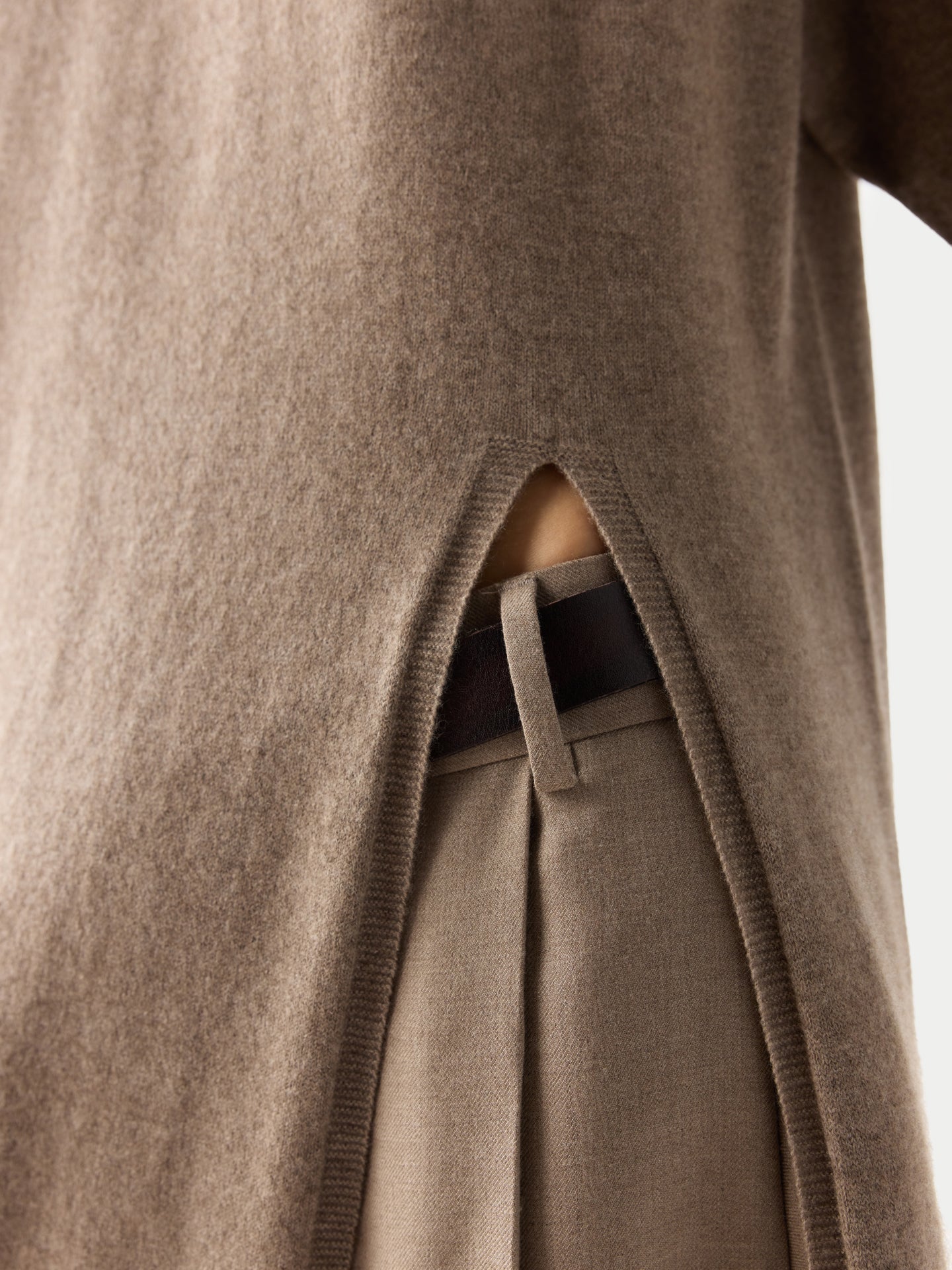 Gros plan sur une robe beige fendue sur le côté, sur fond gris clair. #color_taupe