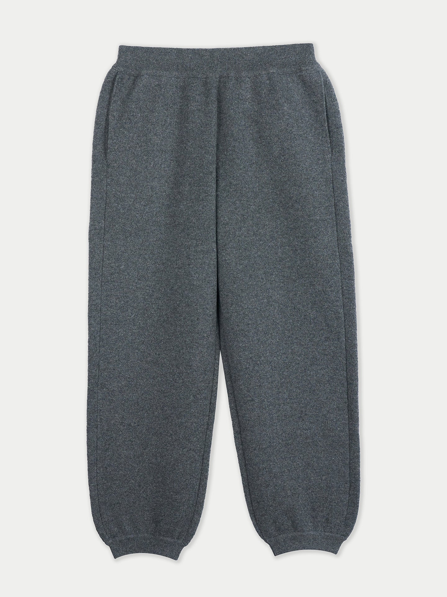 Vue de face d'une femme portant un pantalon de jogging gris sur fond gris clair. #color_india-ink