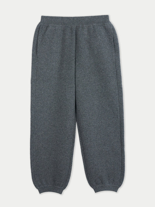 Vue de face d'une femme portant un pantalon de jogging gris sur fond gris clair. #color_india-ink