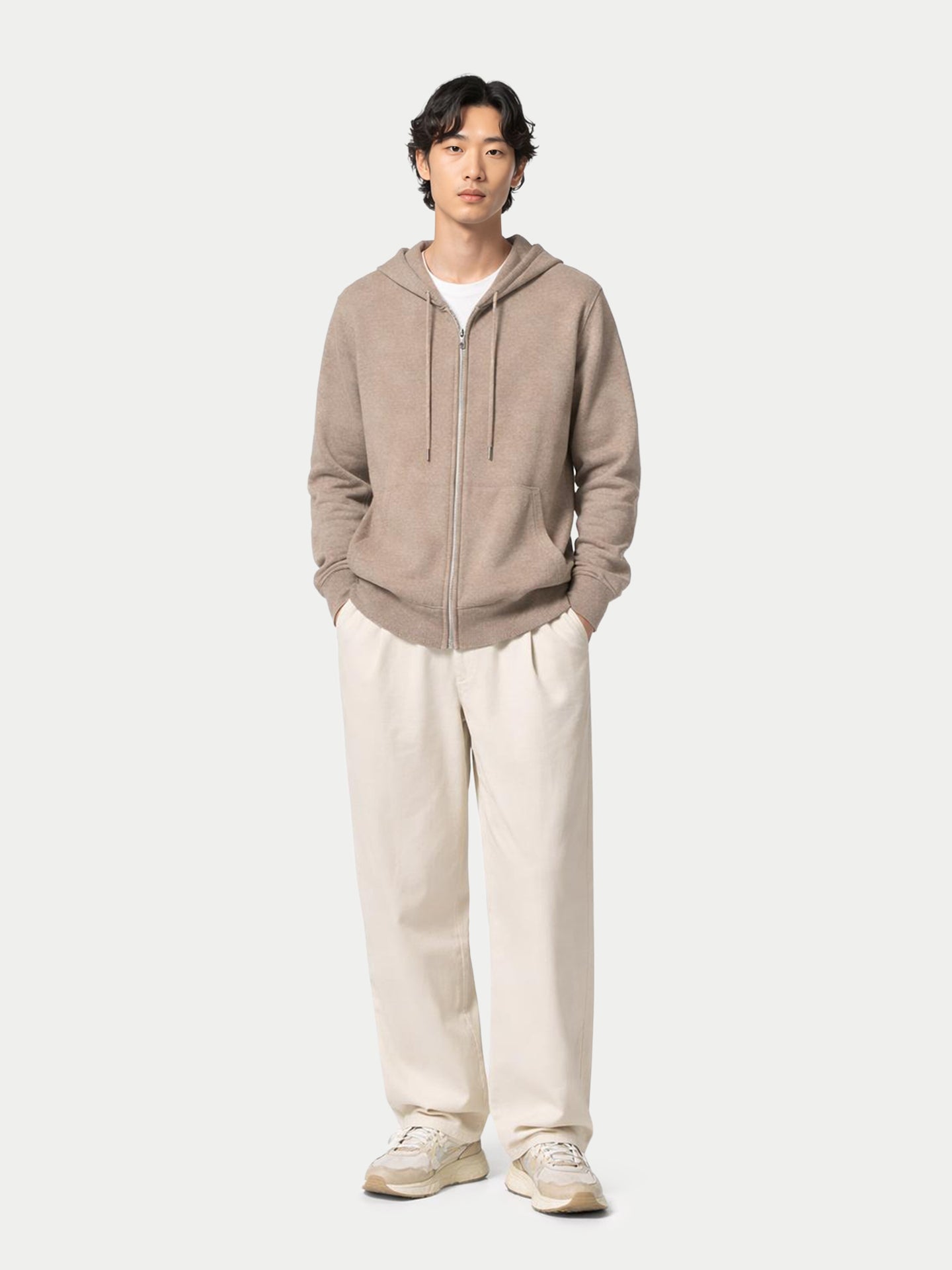 Vue de face d'un homme portant un sweat à capuche beige sur un t-shirt blanc et un pantalon blanc, sur fond gris clair. #color_beige