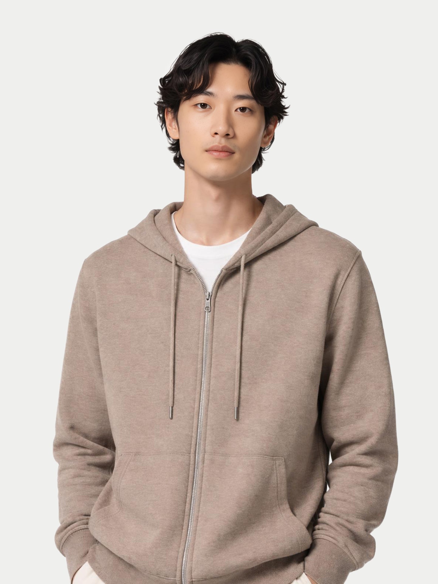 Gros plan de face d'un homme portant un sweat à capuche beige sur un t-shirt blanc, sur fond gris clair. #color_beige