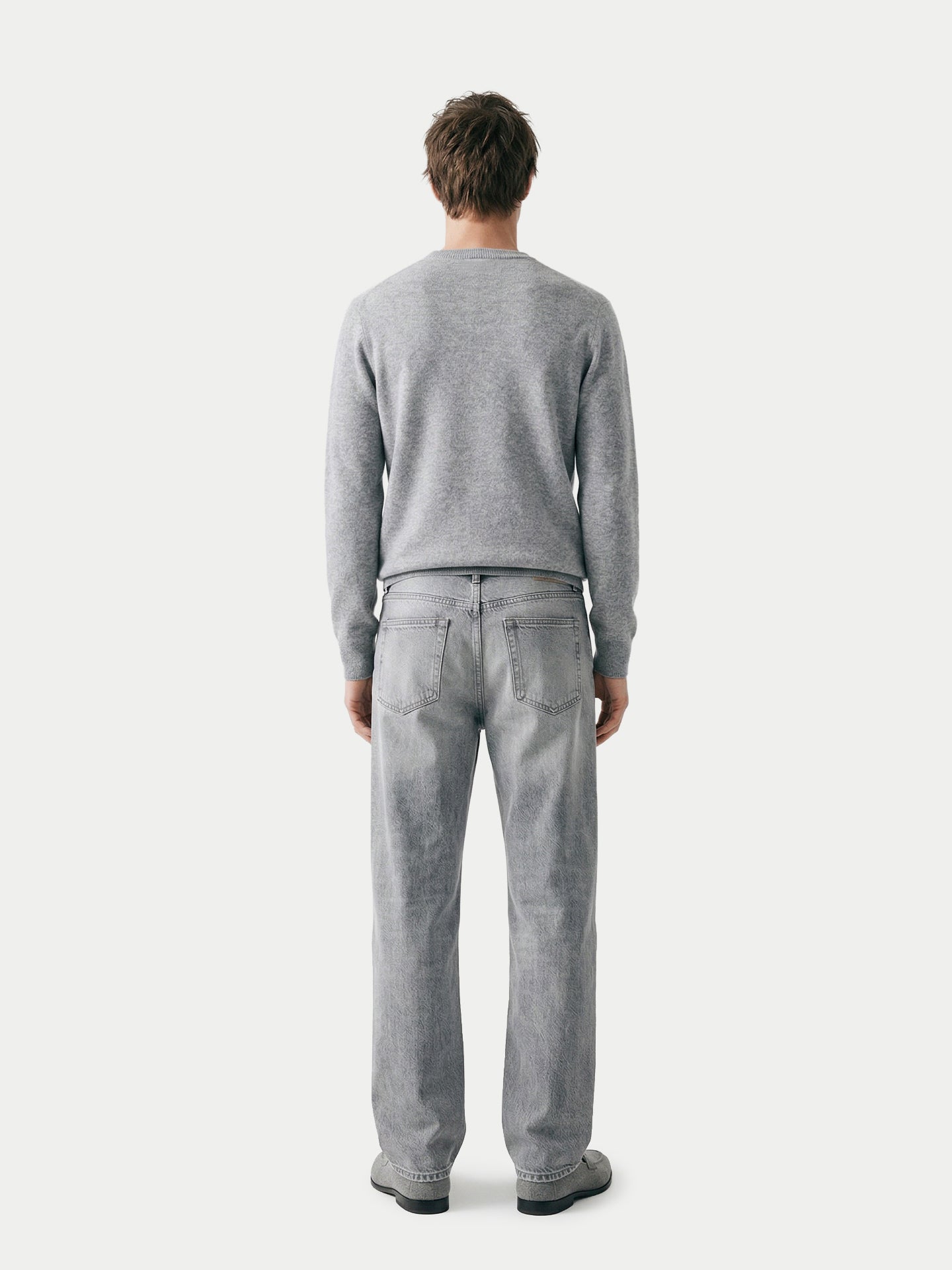 Vue de dos d'un homme portant un pull gris à col rond et un jean sur fond gris clair. #color_high-rise