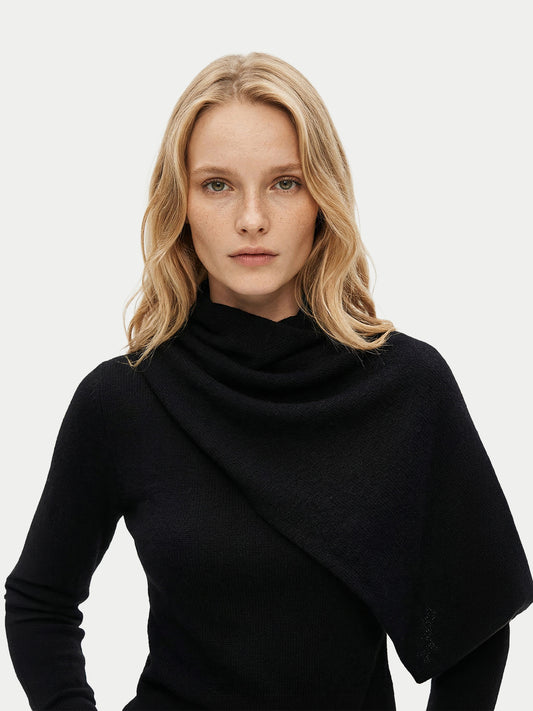 Vue de face d'une femme portant un pull noir à manches longues avec une écharpe intégrée, sur un fond gris clair. #color_noir