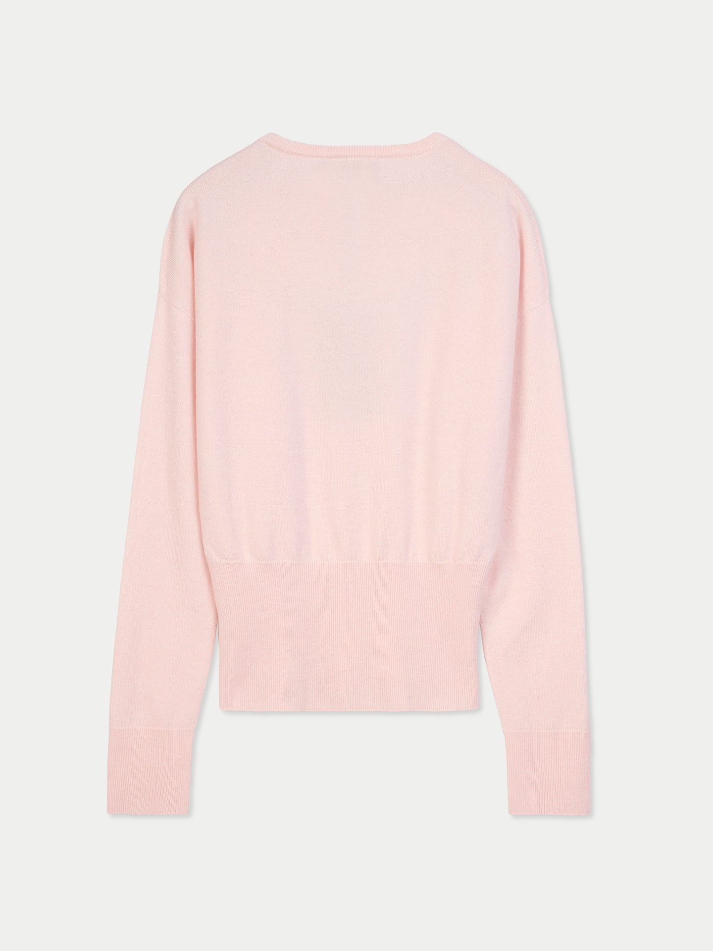 Vue de dos d'un pull rose clair à manches longues, avec poignets et taille côtelés, sur fond gris clair. #color_peach-blush