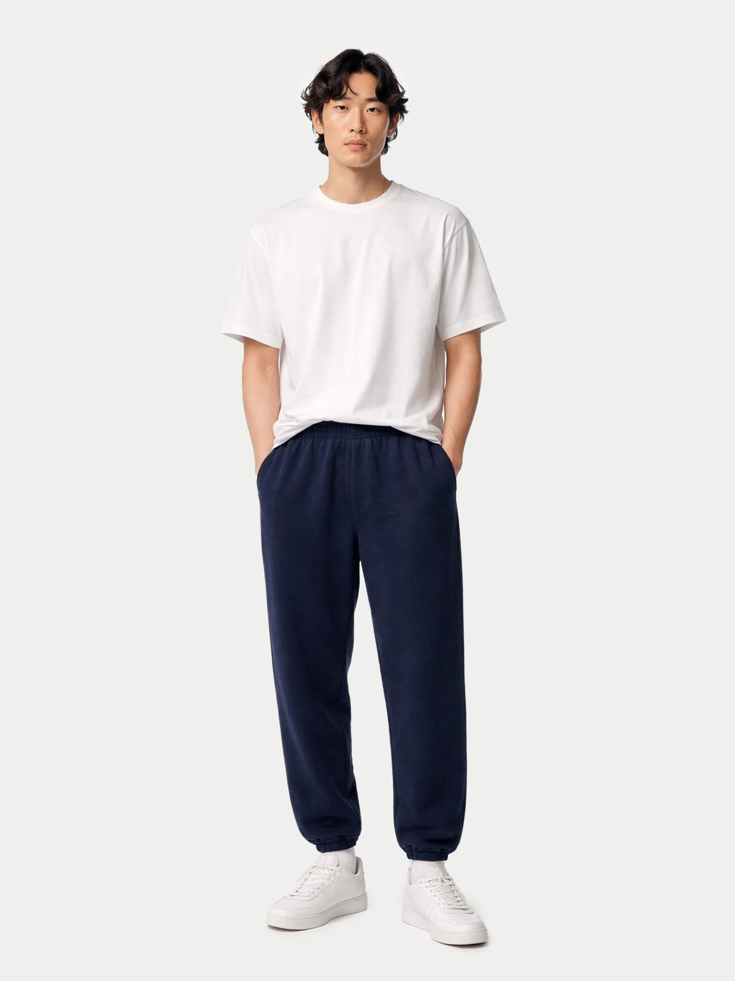 Vue de face d'un homme portant un t-shirt blanc et un pantalon de jogging bleu marine à poches.
#color_india-ink